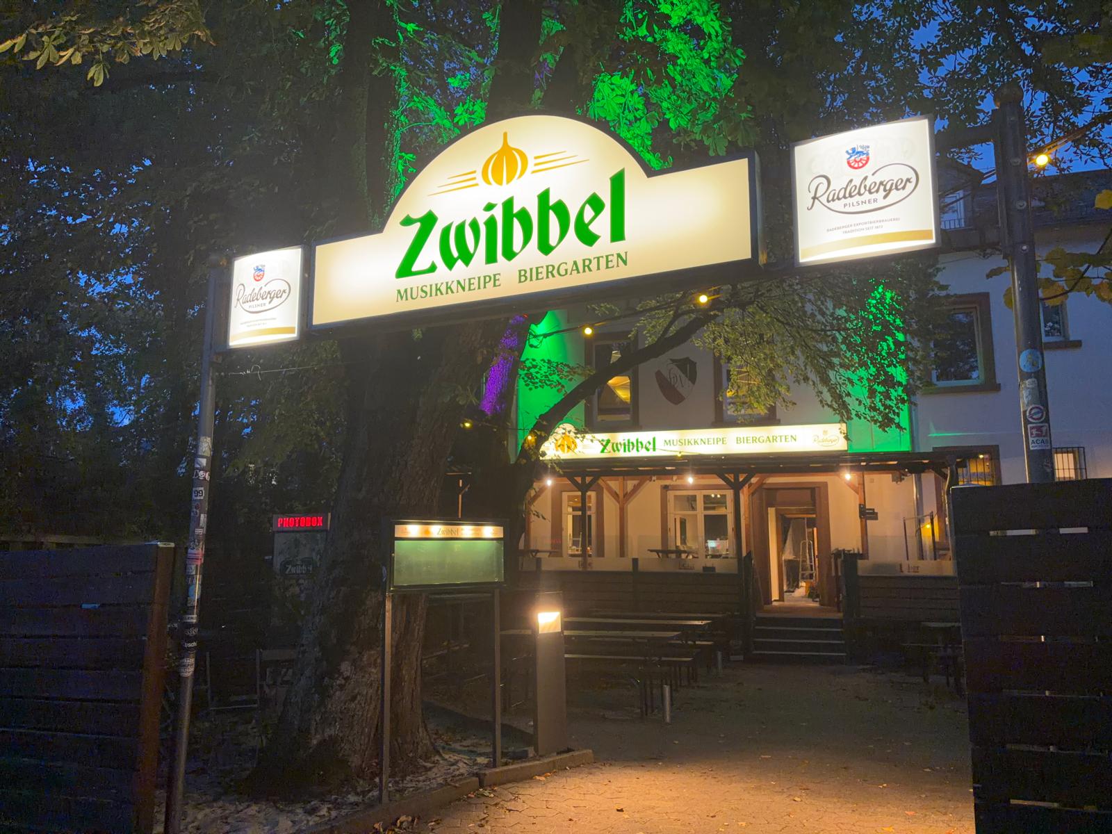 Gastraum der Zwibbel mit Holztischen und warmem Licht
